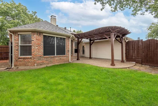 a view of a house with backyard and a garden