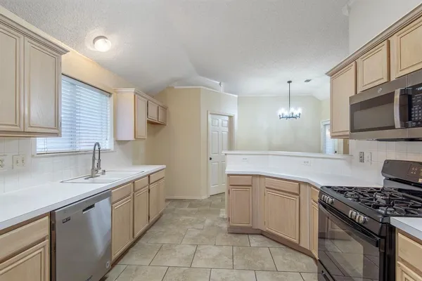 a kitchen with a sink stove top oven and cabinets