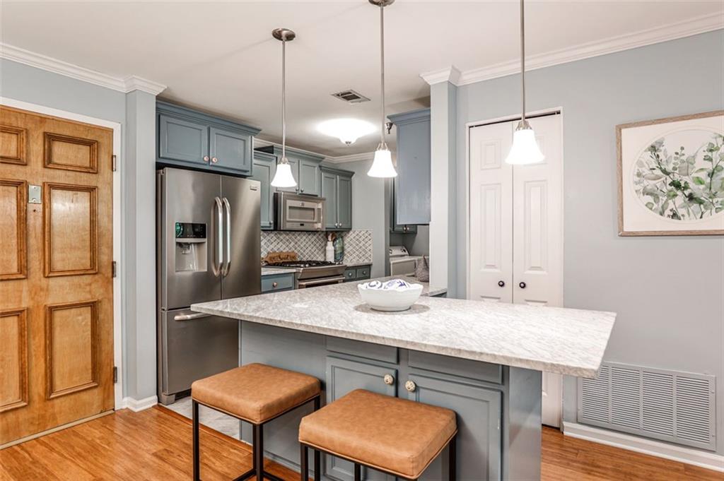 a kitchen with stainless steel appliances granite countertop a sink refrigerator and microwave