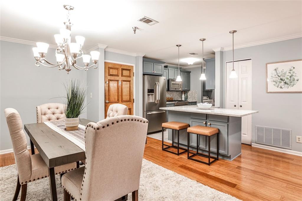 214 Ridley Howard Court Decatur, GA 30030 - Photo 3 of 28 a living room with dining table a couches and kitchen view with wooden floor
