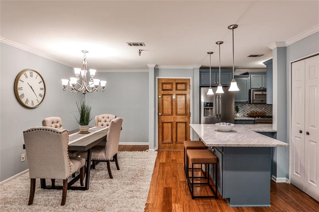 214 Ridley Howard Court Decatur, GA 30030 - Photo 9 of 28 a dining room with wooden floor a chandelier a wooden table and chairs