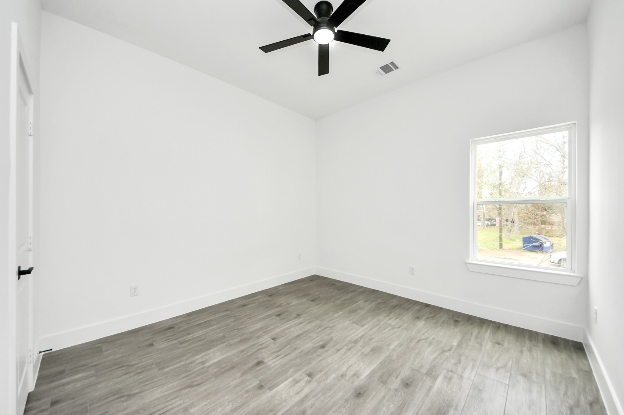 7412 Carver Road, Unit B Houston, TX 77088 - Photo 18 of 22 an empty room with wooden floor and windows
