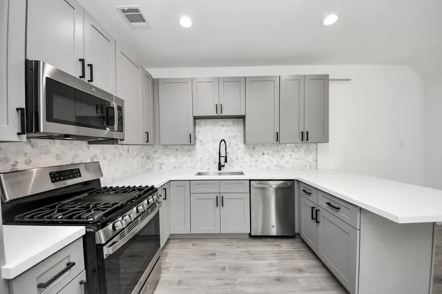 a kitchen with a sink stove and microwave