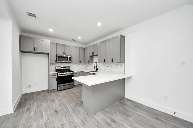 a kitchen with stainless steel appliances a sink stove and refrigerator