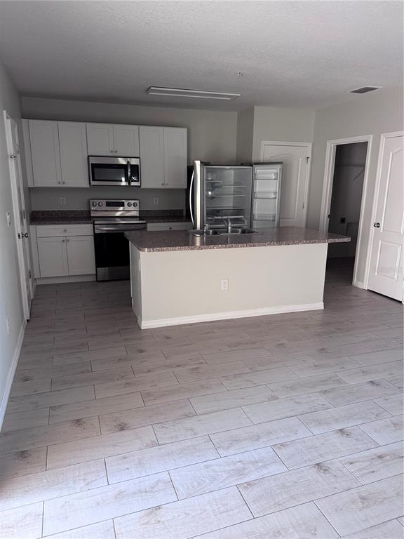 1613 Reflection Cove St. Cloud, FL 34771 - Photo 2 of 10 a view of kitchen with cabinets and refrigerator