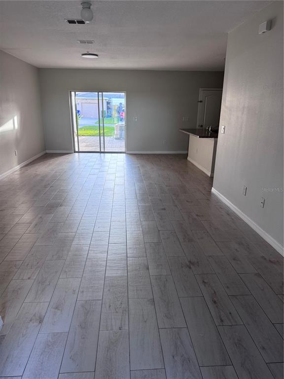 1613 Reflection Cove St. Cloud, FL 34771 - Photo 4 of 10 an empty room with wooden floor and windows