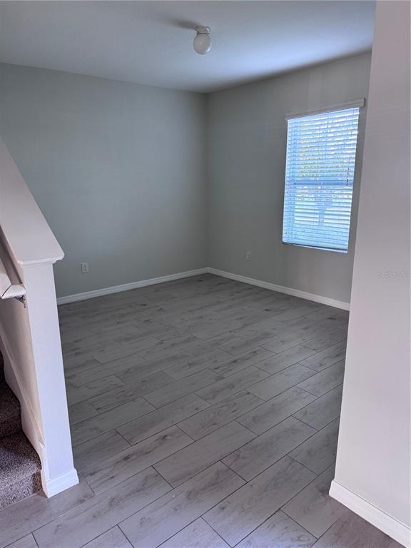 1613 Reflection Cove St. Cloud, FL 34771 - Photo 8 of 10 an empty room with wooden floor and windows