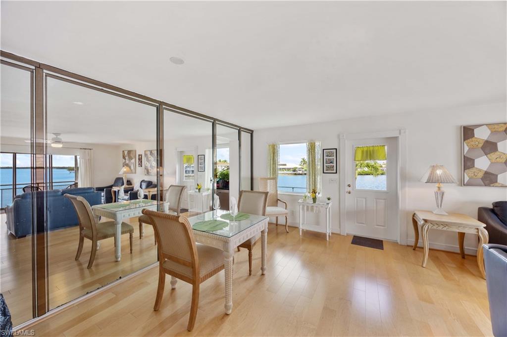 330 Kon Tiki Drive, Unit A2 Naples, FL 34113 - Photo 12 of 39 a view of a dining room with furniture and wooden floor