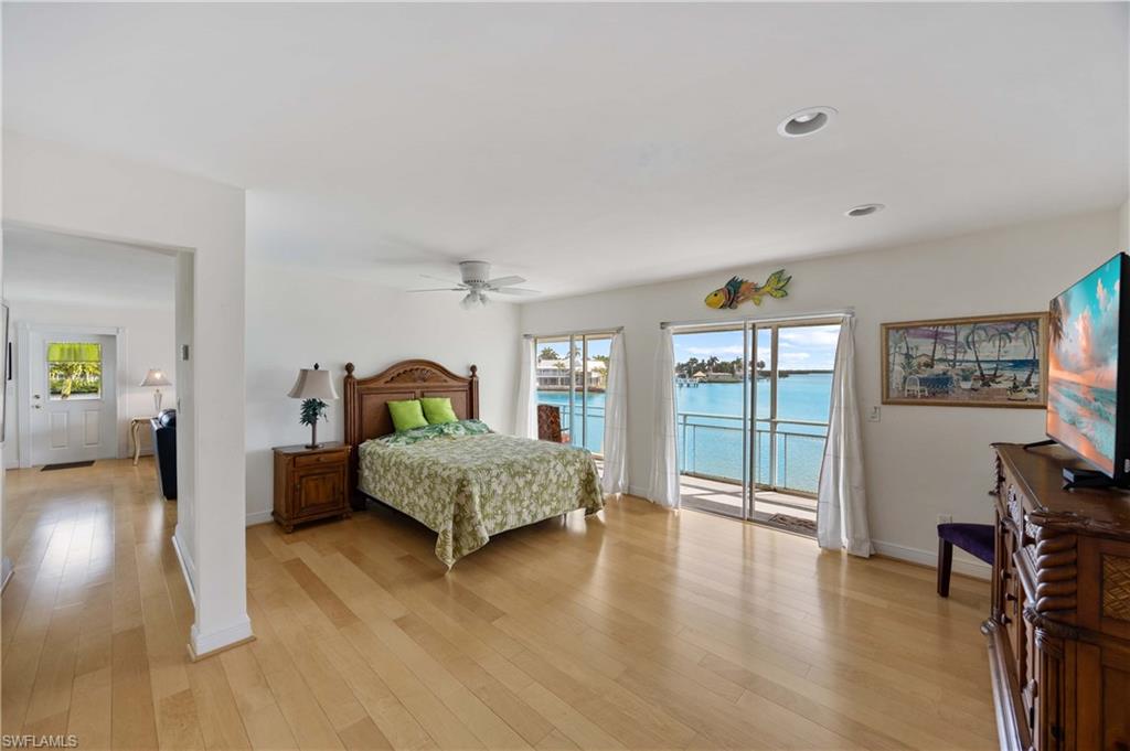 330 Kon Tiki Drive, Unit A2 Naples, FL 34113 - Photo 18 of 39 a bedroom with a bed and wooden floor