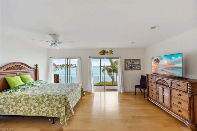 a bedroom with a bed and a flat tv screen on dresser