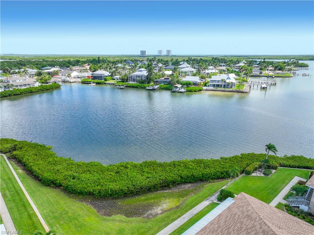 330 Kon Tiki Drive, Unit A2 Naples, FL 34113 - Photo 30 of 39 a view of a lake with houses in the back