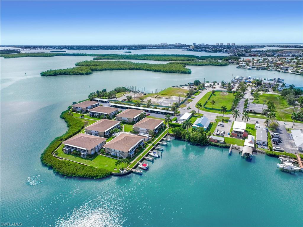 330 Kon Tiki Drive, Unit A2 Naples, FL 34113 - Photo 5 of 39 a view of a lake with lawn chairs