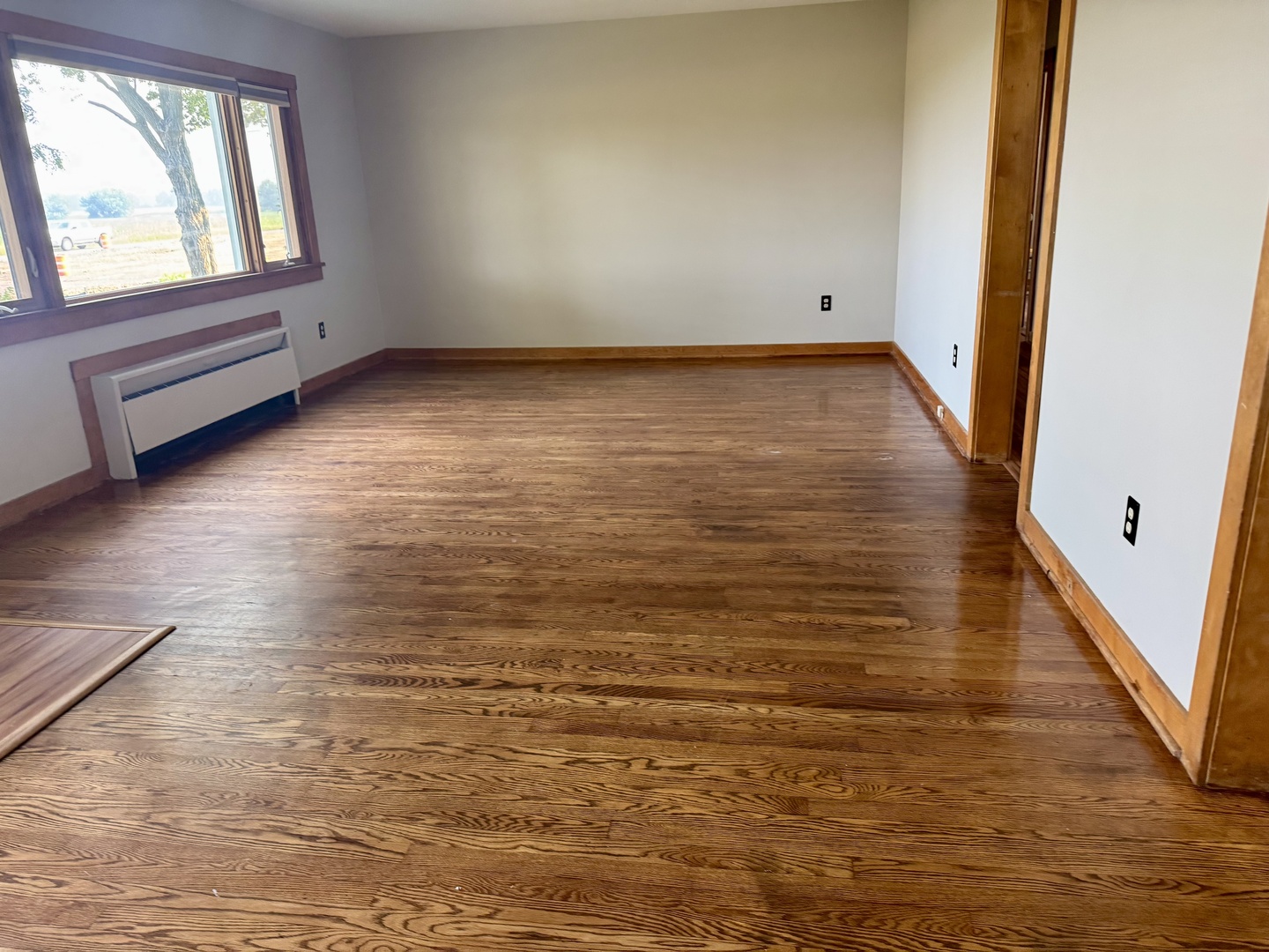 6809 Highway 71 Oswego, IL 60543 - Photo 15 of 20 a view of an empty room with wooden floor and a window