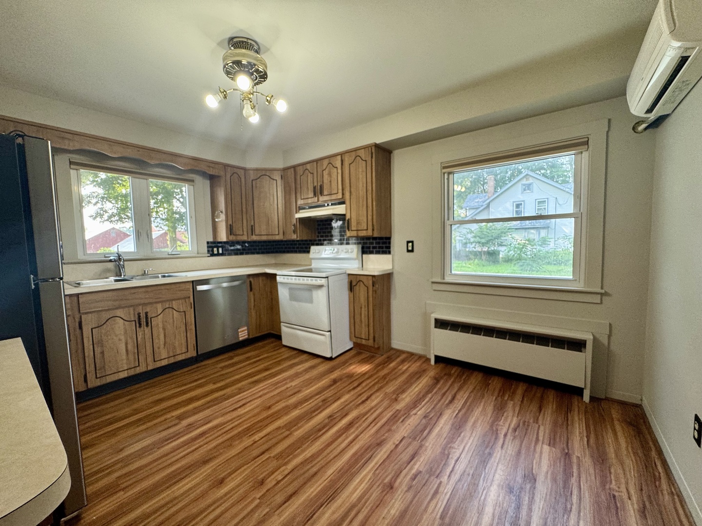 6809 Highway 71 Oswego, IL 60543 - Photo 16 of 20 a kitchen with a sink wooden floors and white appliances