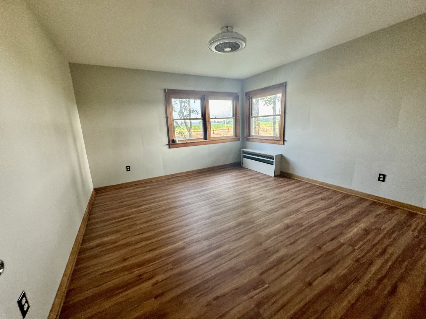 6809 Highway 71 Oswego, IL 60543 - Photo 10 of 20 a view of an empty room with wooden floor and a window