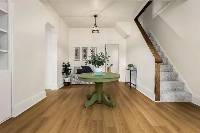 a view of a livingroom with furniture a table and chair with wooden floor