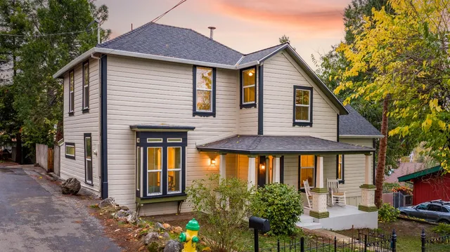 an aerial view of a house with a yard and a large tree