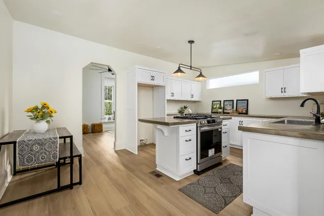 a kitchen with stainless steel appliances kitchen island granite countertop a stove a sink and a refrigerator