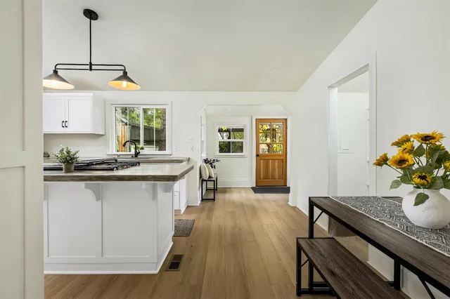 a kitchen with sink refrigerator dining table and chairs