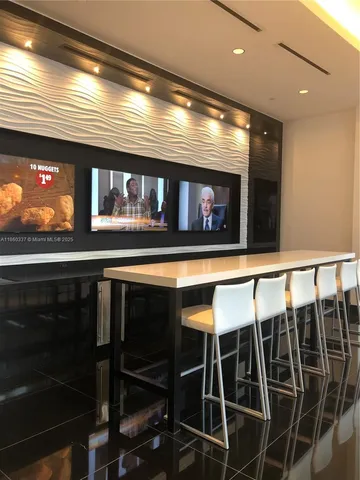 a dining room with furniture and floor to ceiling window