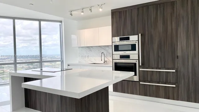 a kitchen with stainless steel appliances a sink and a refrigerator