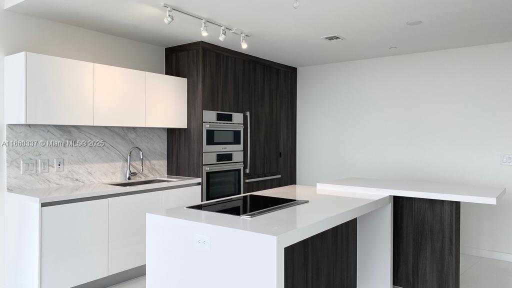 851 Northeast 1st Avenue, Unit 3904 Miami, FL 33132 - Photo 22 of 28 a kitchen with stainless steel appliances a sink and a refrigerator