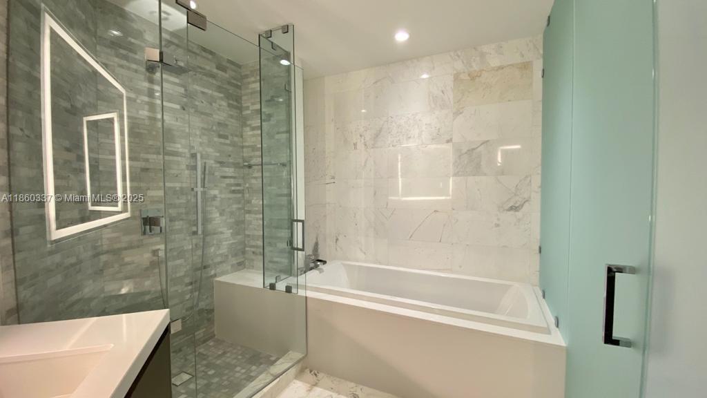851 Northeast 1st Avenue, Unit 3904 Miami, FL 33132 - Photo 25 of 28 a bathroom with a bathtub and a shower