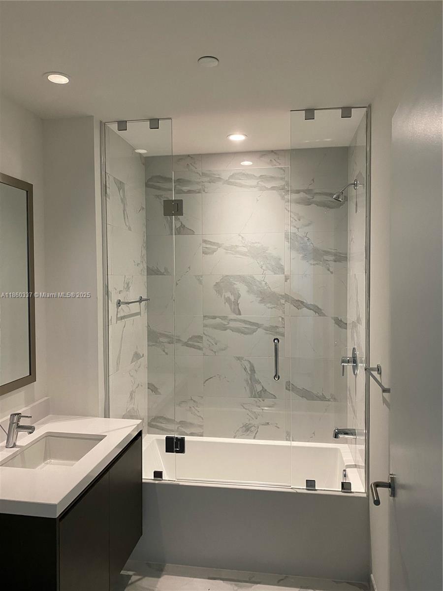 851 Northeast 1st Avenue, Unit 3904 Miami, FL 33132 - Photo 27 of 28 a bathroom with a sink and a mirror