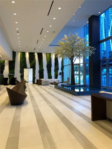 a lobby with a couch and a potted plant