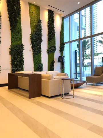 a view of a room with a large window and wooden floor