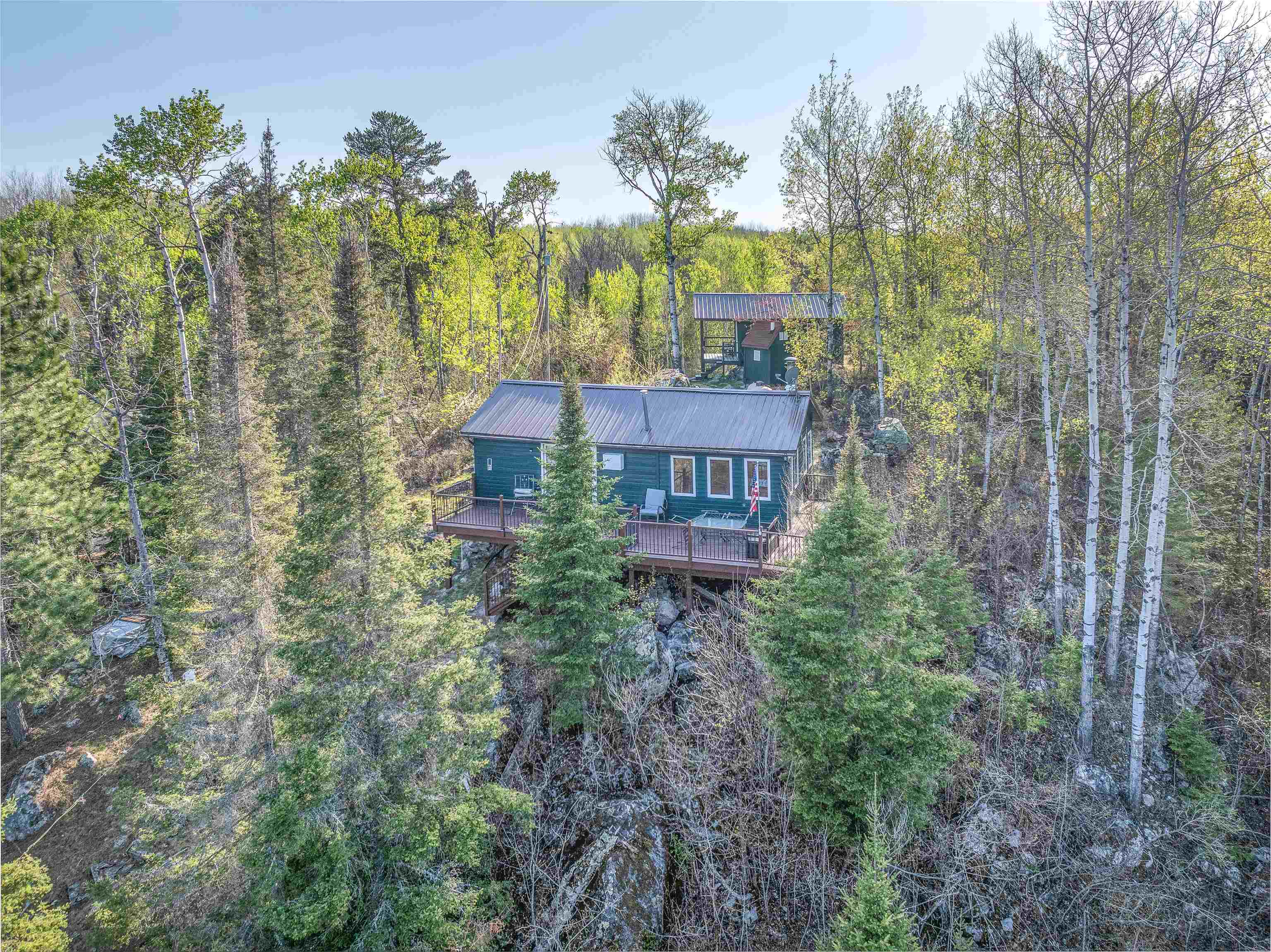 2377 Finn Road Babbitt, MN 55706 - Photo 28 of 32 Rear view of property featuring metal roof, a wooded view, and a deck