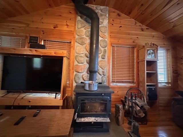 2377 Finn Road Babbitt, MN 55706 - Photo 9 of 32 Living area with lofted ceiling, a wood stove, wood ceiling, wooden walls, and wood finished floors
