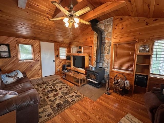 2377 Finn Road Babbitt, MN 55706 - Photo 10 of 32 Living area featuring wooden ceiling, a wood stove, vaulted ceiling, healthy amount of natural light, and wood walls