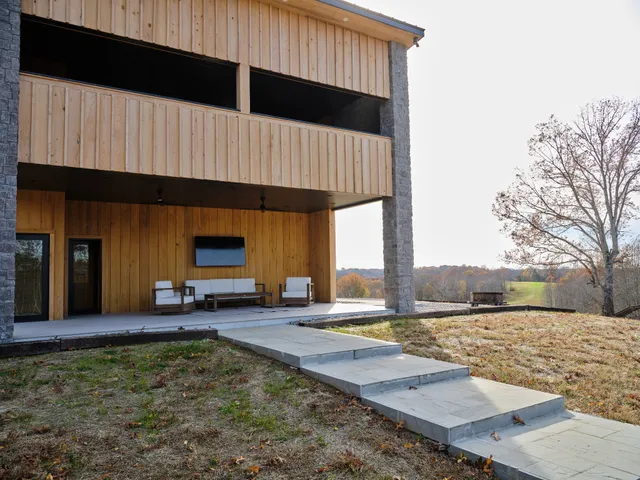 a view of house with a yard and a large tree