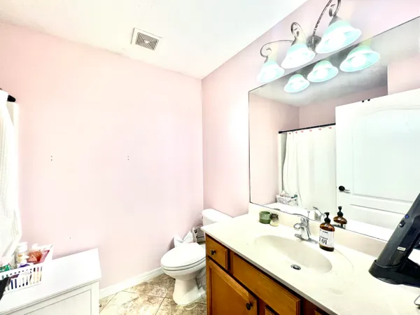 a bathroom with a sink vanity mirror and toilet