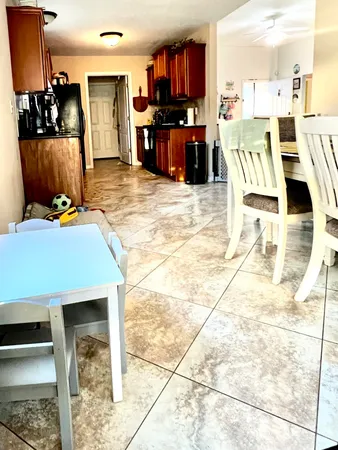 a living room with furniture a flat screen tv and kitchen view