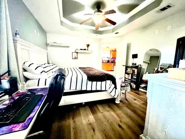 a bedroom with furniture and a wooden floor