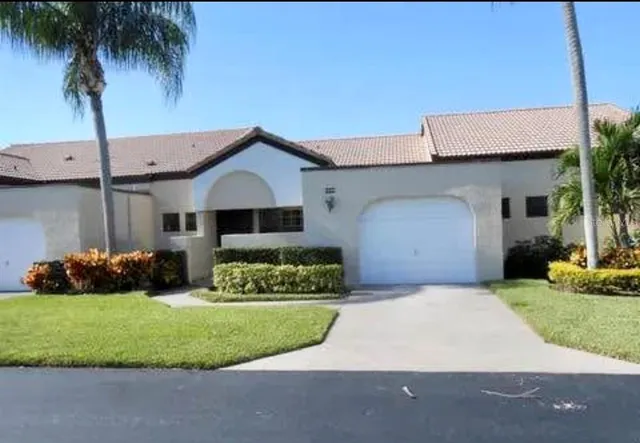a front view of a house with a garden and yard