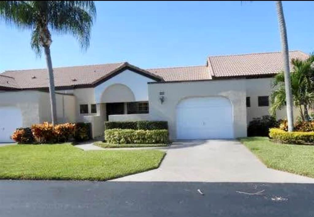 a front view of a house with a garden and yard