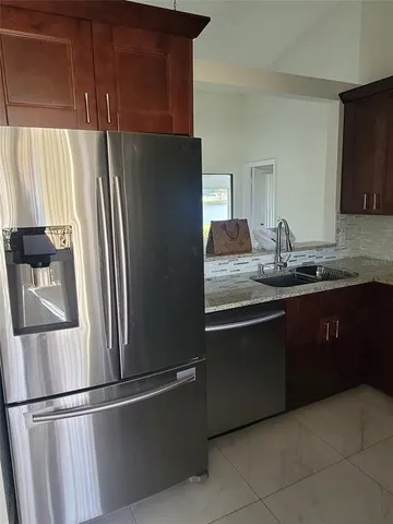 a kitchen with stainless steel appliances granite countertop a refrigerator and a sink