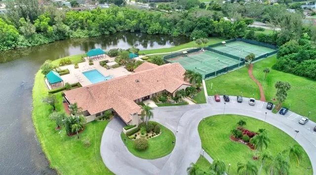 an aerial view of a house with outdoor space and a lake view in back yard