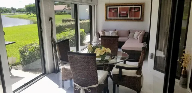 a dining room with furniture and floor to ceiling window