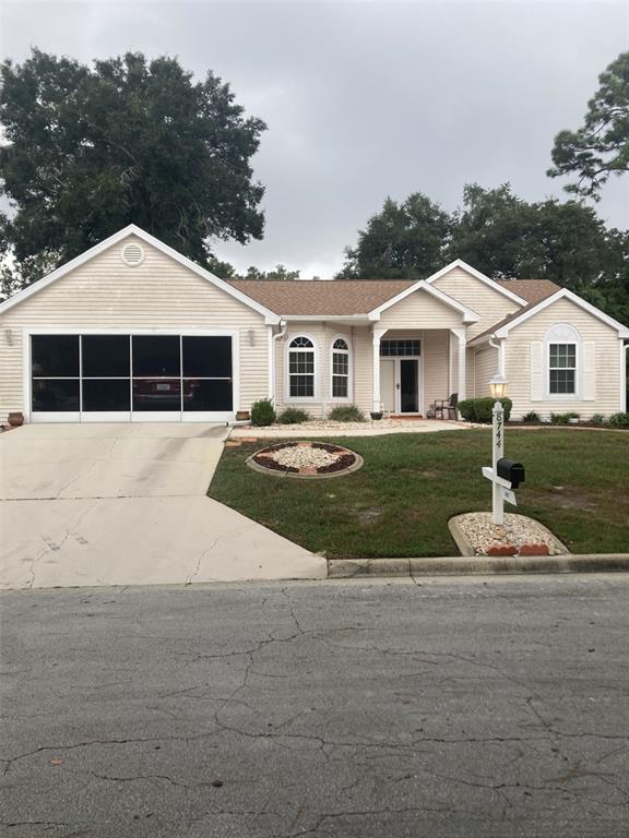 8744 Southwest 108th Ln Road Ocala, FL 34481 - Photo 1 of 28 a front view of a house with a yard and garage