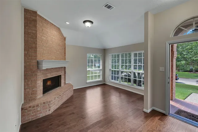 a view of a livingroom with wooden floor and a fireplace