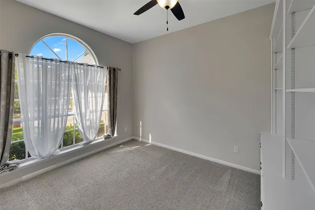 an empty room with windows and balcony