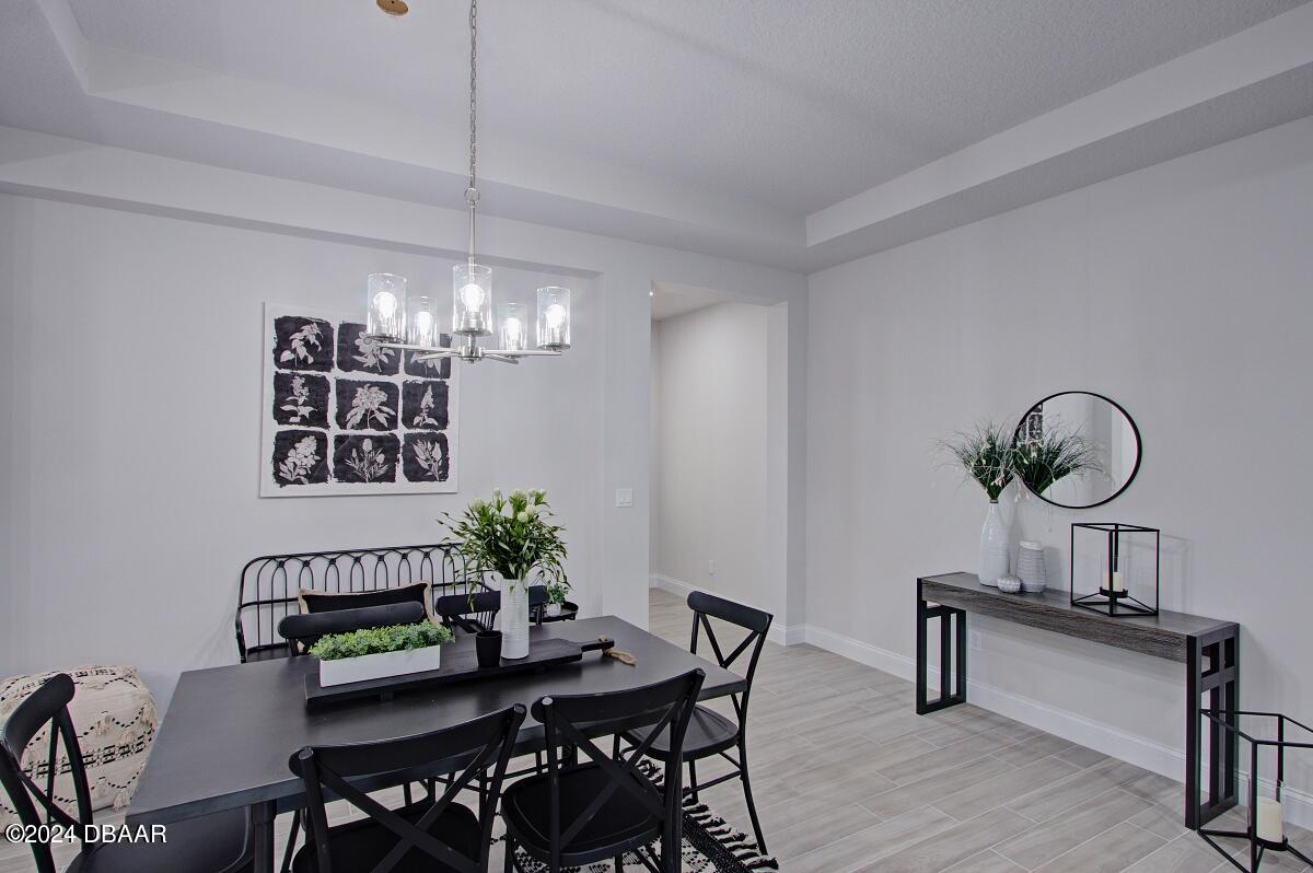 8 Finch Walk Road Ormond Beach, FL 32174 - Photo 6 of 18 a view of a dining room and kitchen furniture a chandelier fan a wooden table and chairs