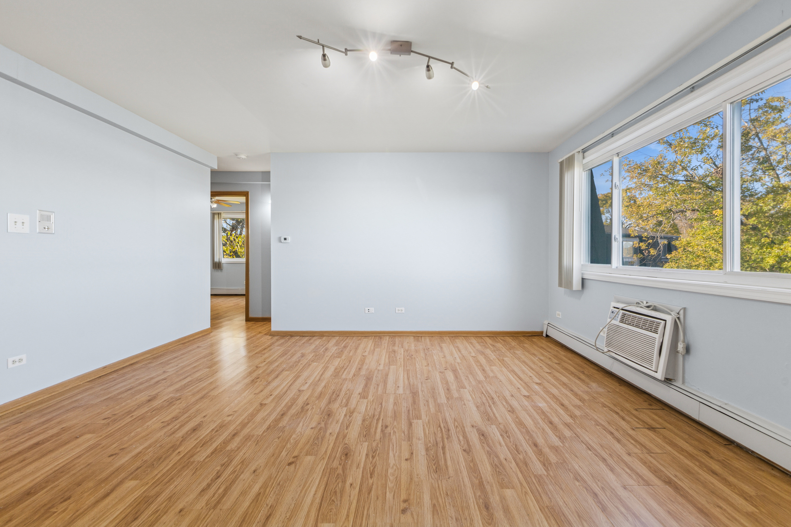 17220 71st Avenue, Unit 11 Tinley Park, IL 60477 - Photo 11 of 20 an empty room with wooden floor and windows