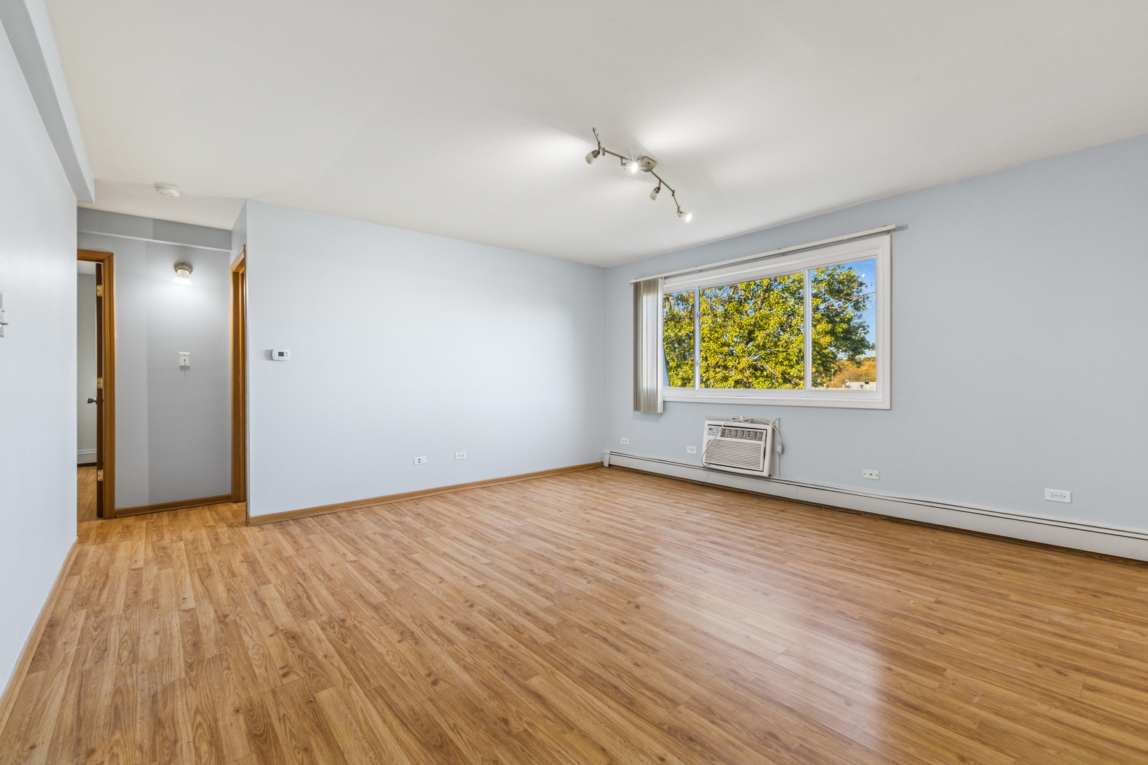 17220 71st Avenue, Unit 11 Tinley Park, IL 60477 - Photo 12 of 20 an empty room with wooden floor and windows