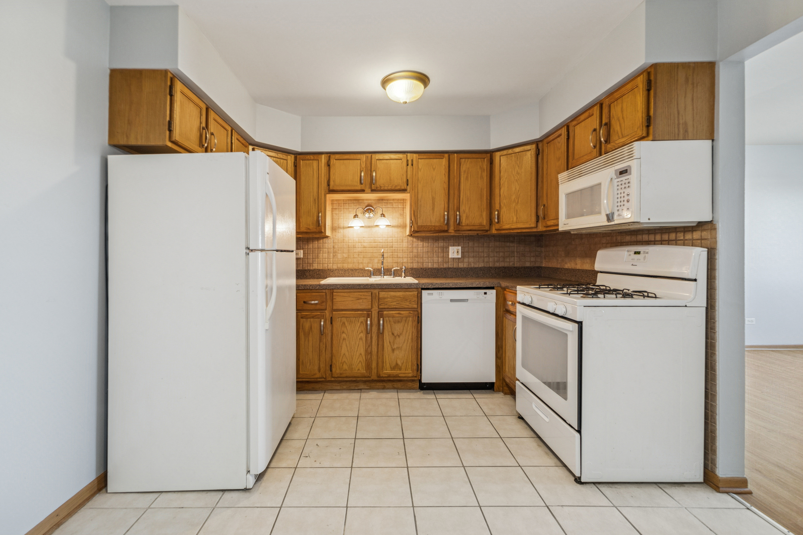 17220 71st Avenue, Unit 11 Tinley Park, IL 60477 - Photo 7 of 20 a kitchen with a sink a refrigerator and cabinets
