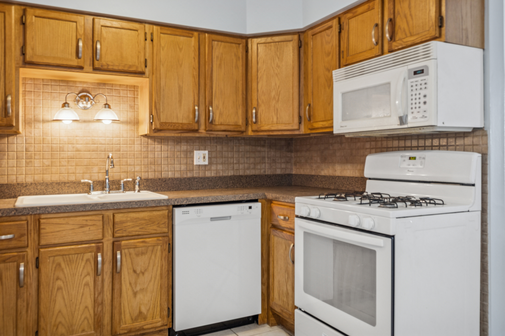 17220 71st Avenue, Unit 11 Tinley Park, IL 60477 - Photo 8 of 20 a kitchen with stainless steel appliances granite countertop a sink stove and cabinets